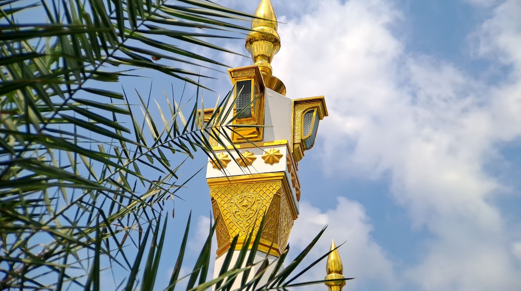 brown gold white color mosque minaret with arabic architecture in madiun indonesia park, sunny weather.