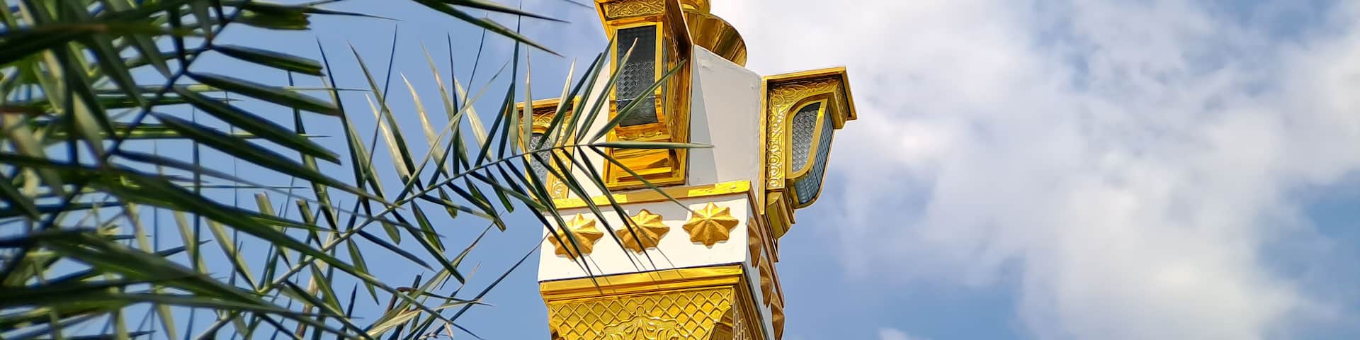 brown gold white color mosque minaret with arabic architecture in madiun indonesia park, sunny weather.