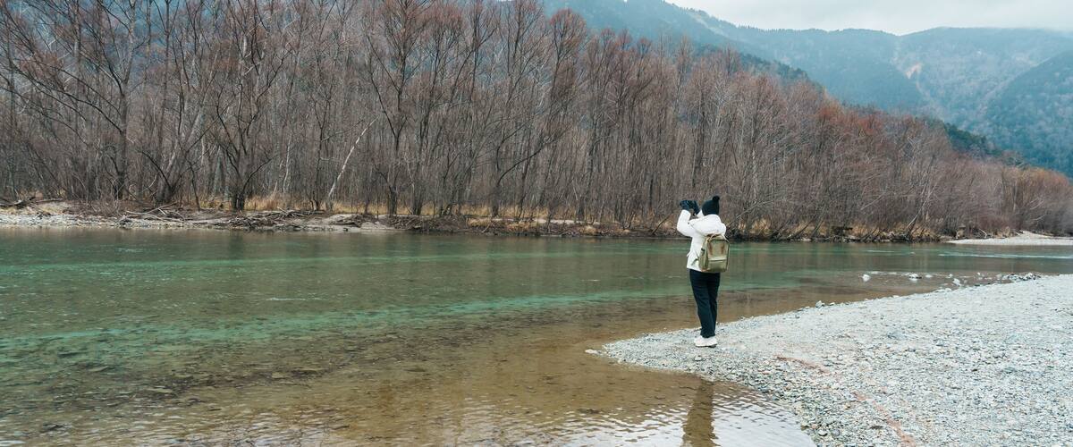 Woman tourist travel Kamikochi National Park, happy Traveler sightseeing Tashiro pond with mountain, Nagano Prefecture, Japan. Landmark for tourists attraction. Japan Travel, Destination and Vacation