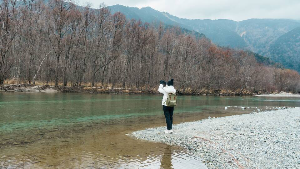 Woman tourist travel Kamikochi National Park, happy Traveler sightseeing Tashiro pond with mountain, Nagano Prefecture, Japan. Landmark for tourists attraction. Japan Travel, Destination and Vacation