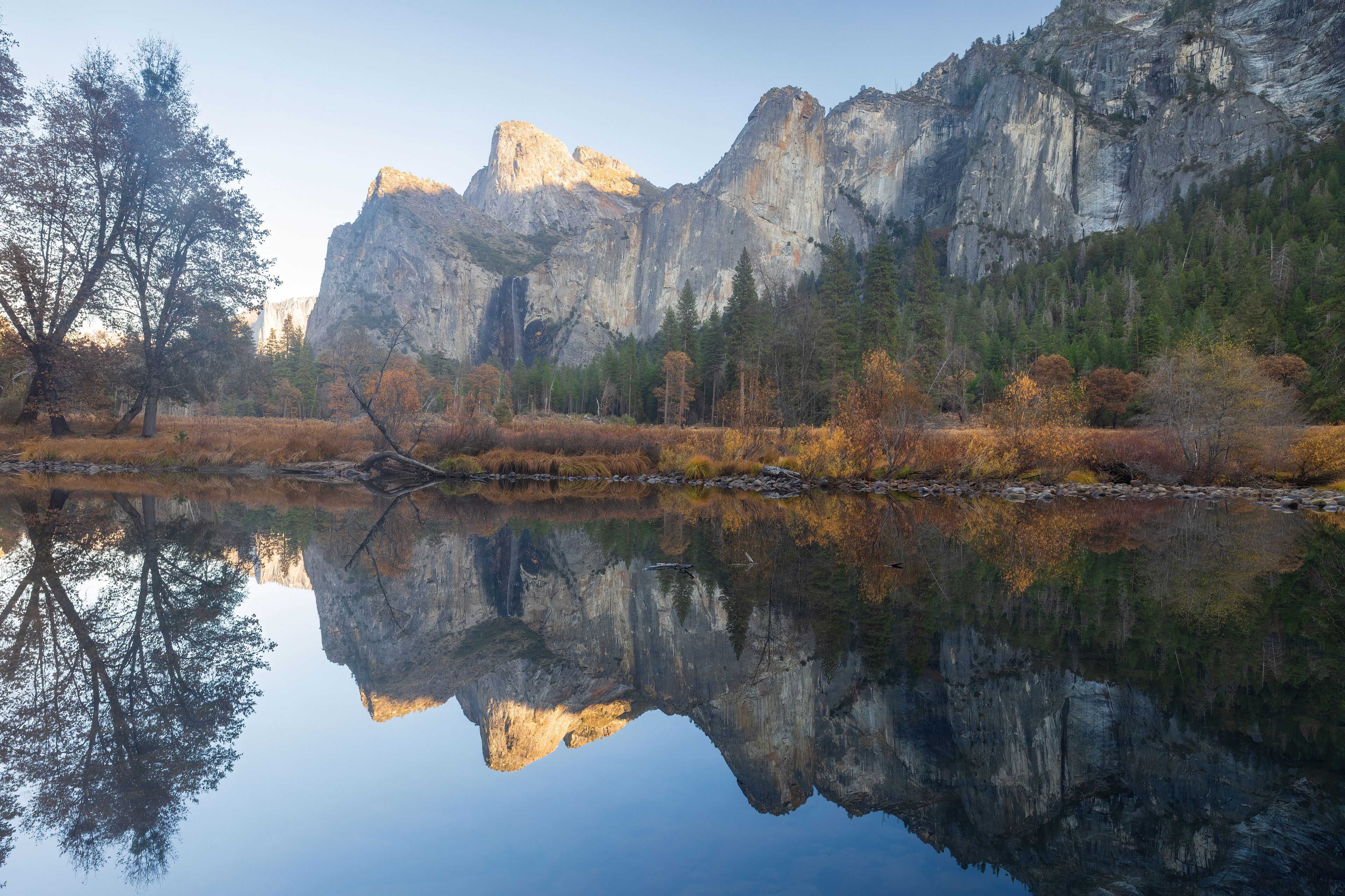 Cathedral Rocks reflecting on Merced River at autumn sunset via Valley View. Yosemite National Park, California, USA.