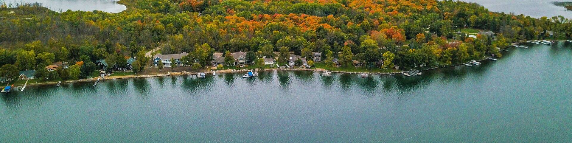 An aerial view of a lakeside community with houses and boats.