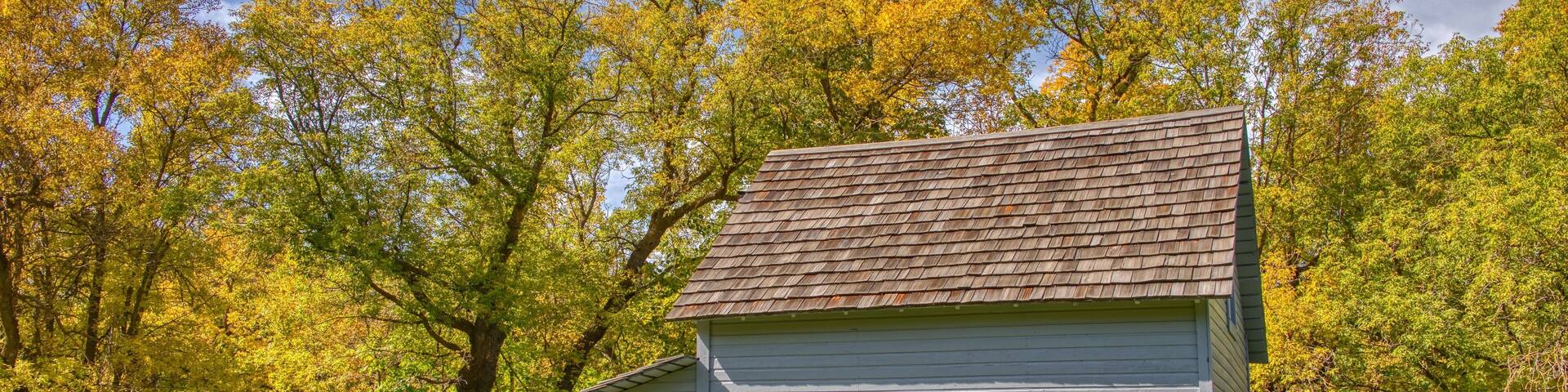 A historic building named Larson Mill surrounded by autumn foliage.