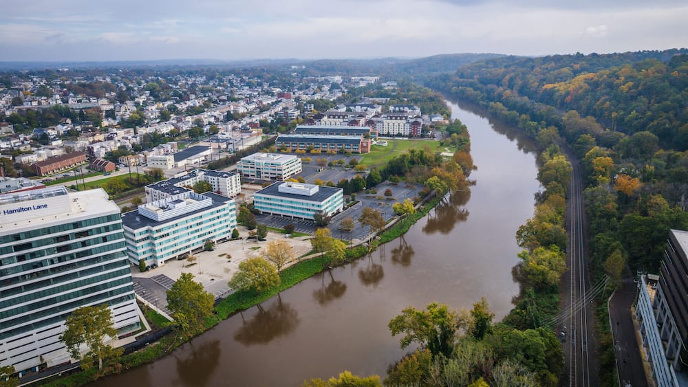 Une rivière qui serpente à travers une ville, avec des bâtiments et un pont.