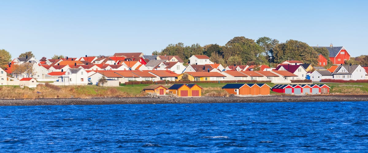 A coastal village with colorful houses and a clear blue sea.