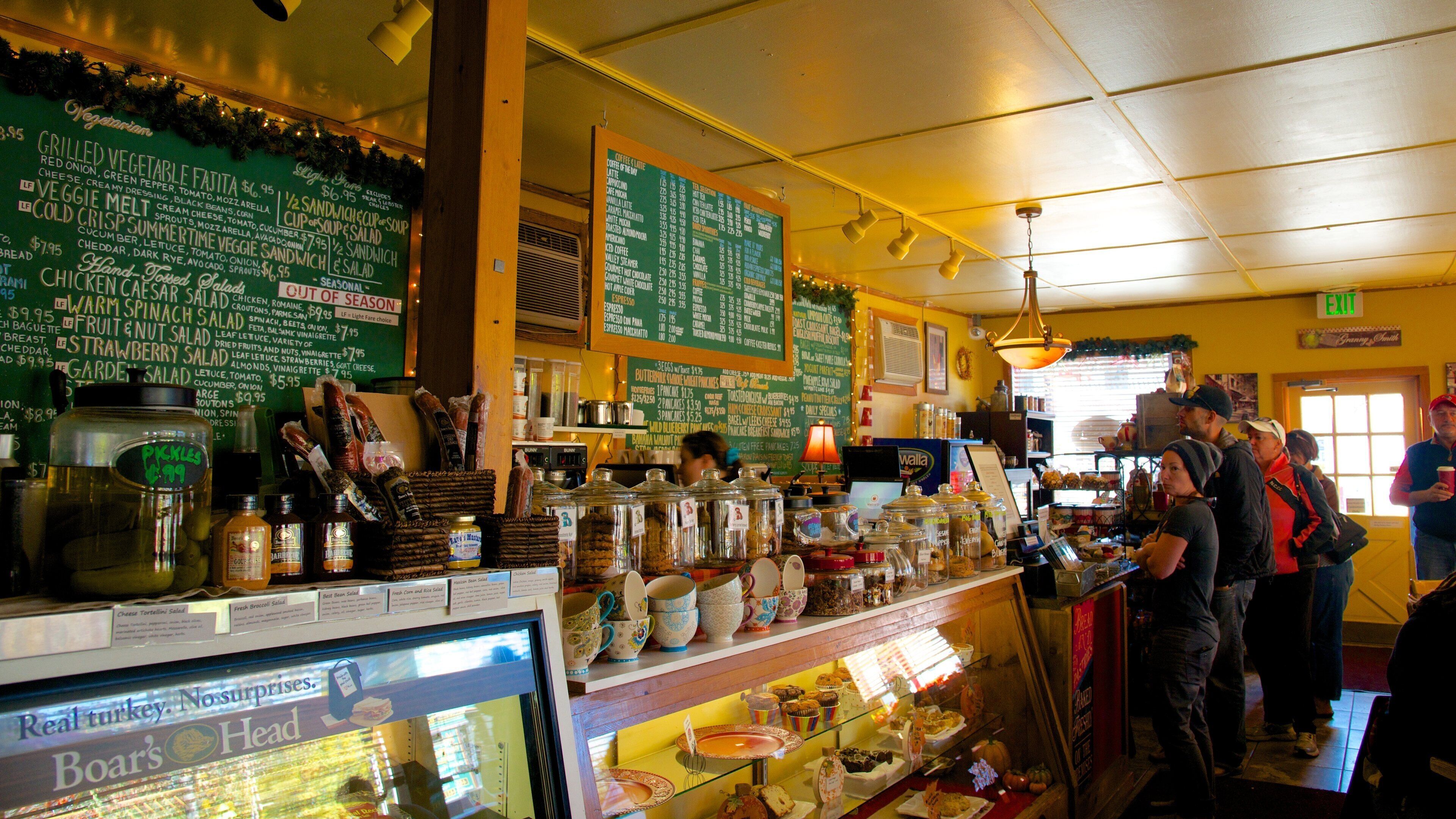 A restaurant with a green menu board listing various dishes and prices.