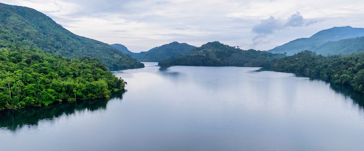 A calm lake surrounded by lush green hills.