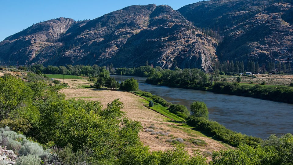 A river winding through a valley with mountains in the background.