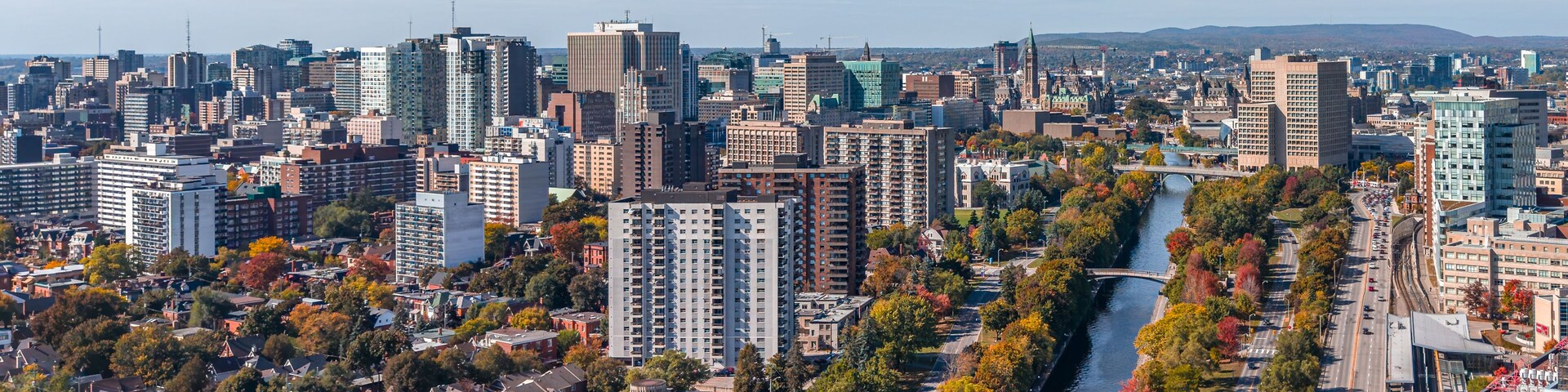 Stunning aerial view of downtown Ottawa, Ontario, Canada, with the Rideau Canal lined with vibrant autumn foliage, Gatineau Hills behind, capturing the beauty of fall in the capital (October 2025)