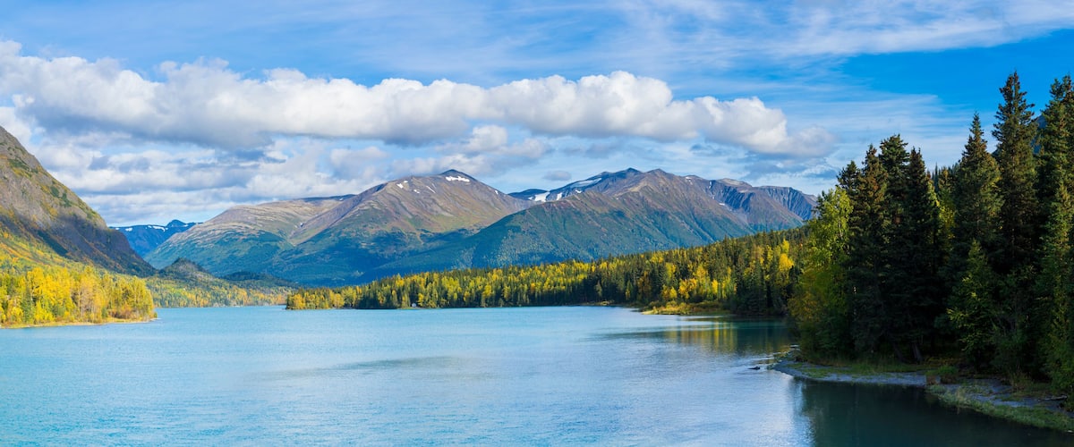 Un lac de montagne entouré de forêts et de montagnes.