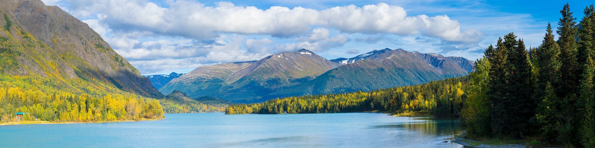 A mountain lake surrounded by forest and mountains.