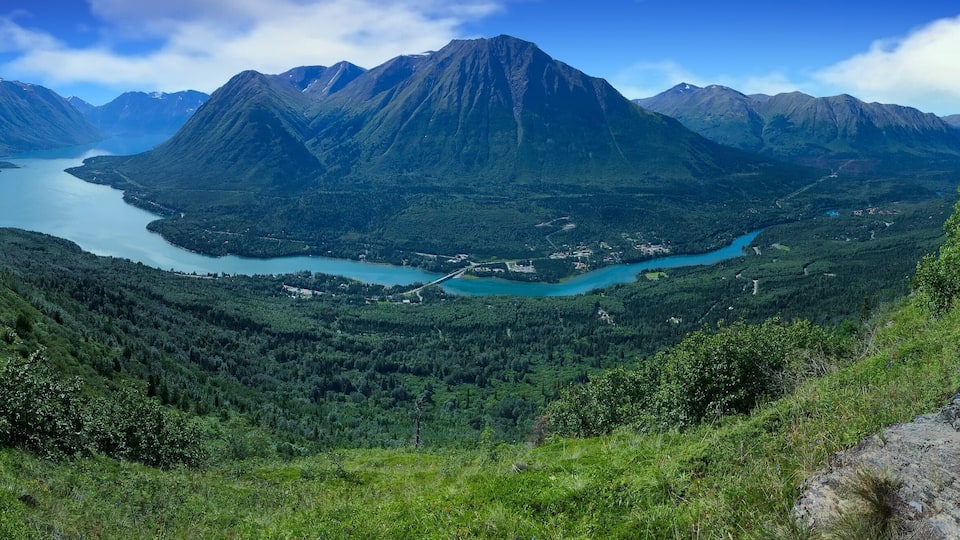 A mountainous landscape with a lake and a hiking trail.