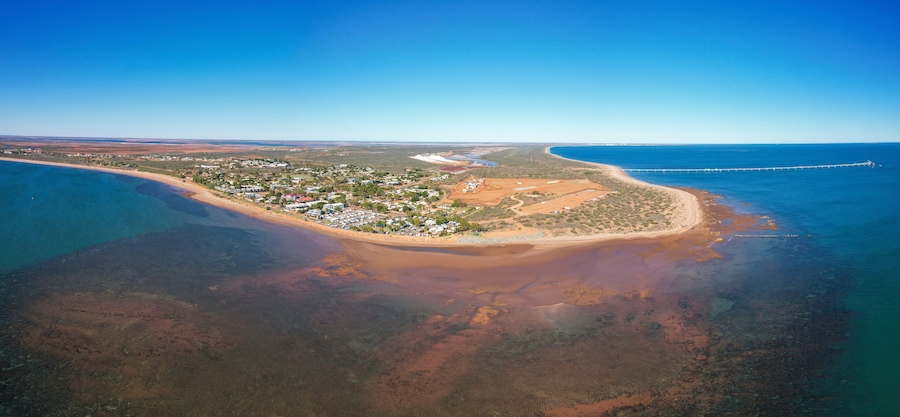 Aerial view of beadon bay at sunset with onslow sunset beach and onslow salt loading jetty, onslow, western australia.