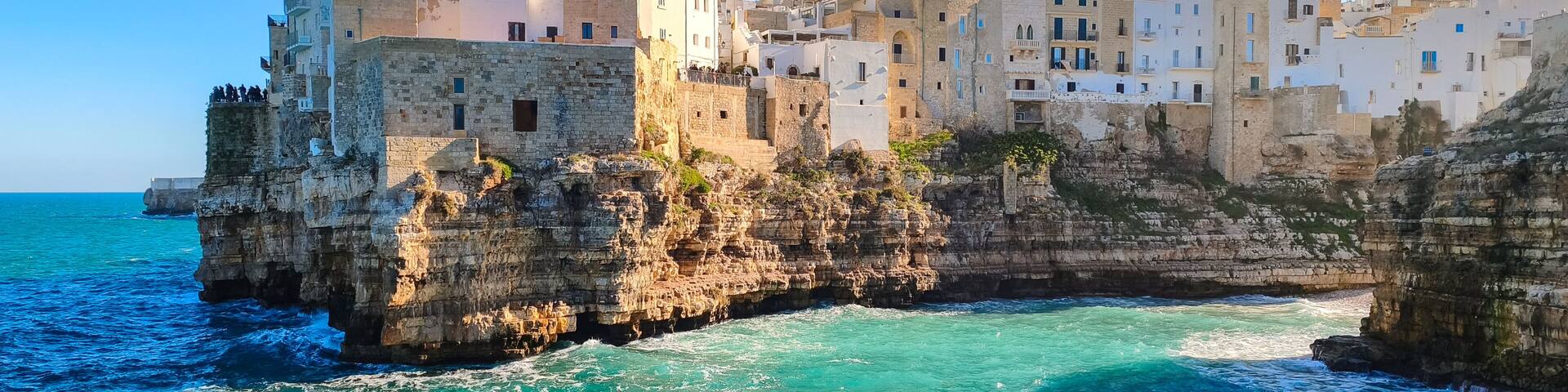 White houses on a rocky cliff in Polignano a Mare in Puglia, seen from Lama Monachile beach