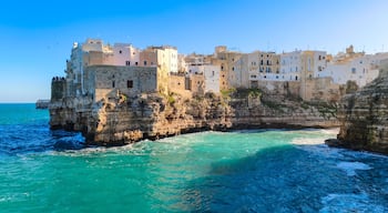 White houses on a rocky cliff in Polignano a Mare in Puglia, seen from Lama Monachile beach