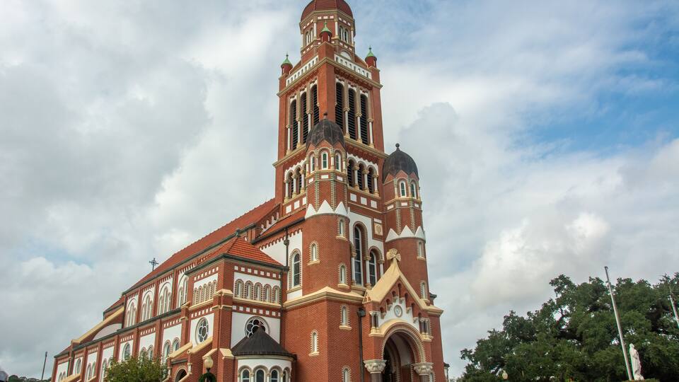 A large, historic church with a tall bell tower and multiple domes.