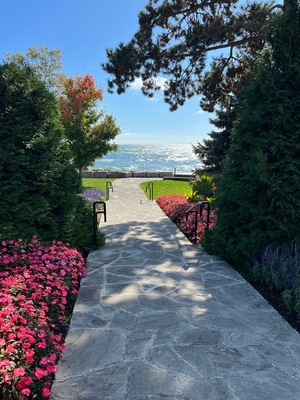 A stone pathway leading to a scenic overlook with a view of the ocean.