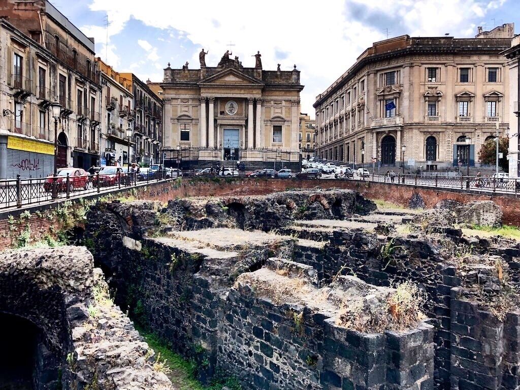 Remains of the Roman Amphitheatre (Anfiteatro) of Catania. The demarcated area in the centre of the square seems to be relatively small – the former amphitheatre, probably built in the 2nd or 3rd Century during the Roman Empire, however, offered space for approximately 16,000 spectators.
Behind the amphitheatre you can see the façade of the Capuchin church.
