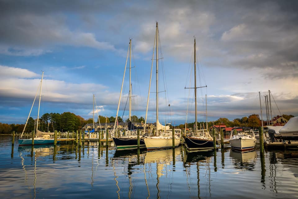 A marina with several sailboats docked in calm waters.