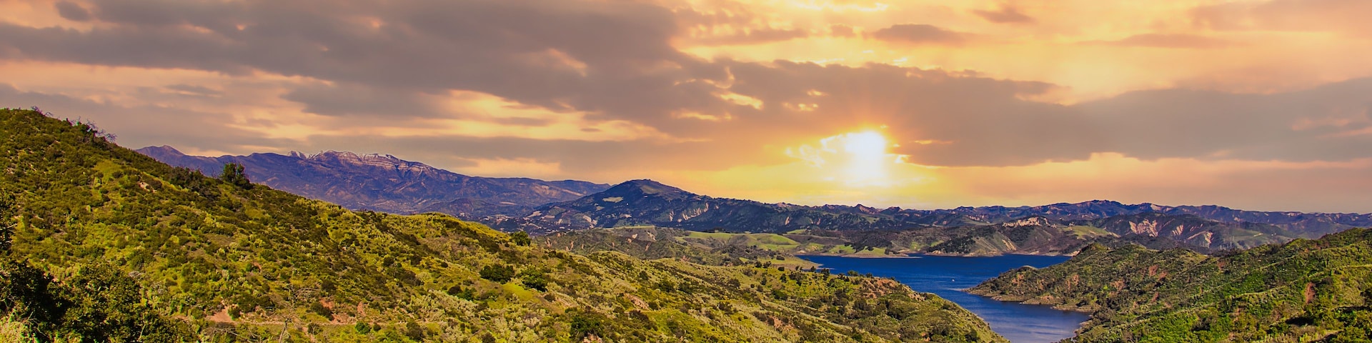 Paisagem montanhosa com um vale e um lago.