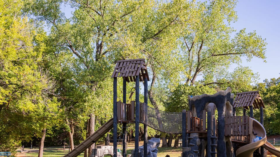 A playground with a slide, climbing structures, and a rope net.