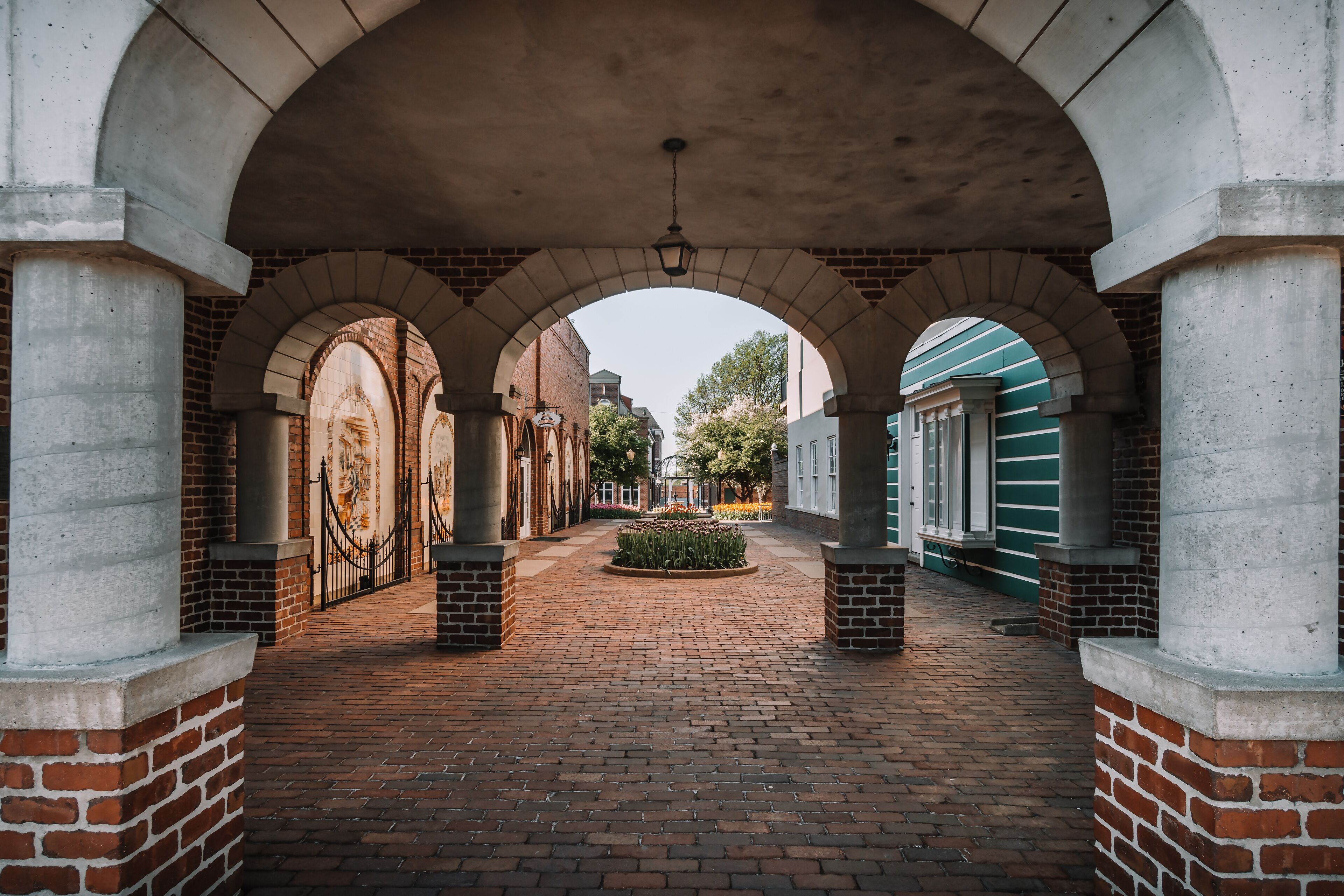 Close up through the arch of the Klokkenspel and views of the courtyard and beds of tulips in the morning hours in Pella, Iowa, USA.
