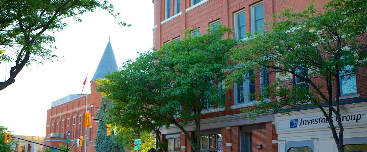 A street with a brick building, a tall tower, and a sign for 'Investor Group'.