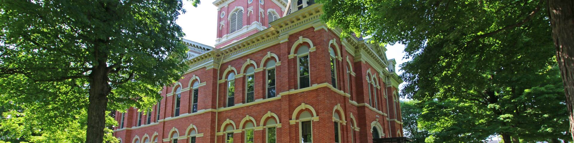 A historic red brick building with arched windows and a clock tower.