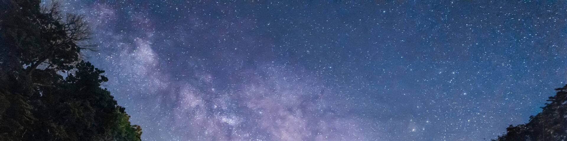 Una cascada bajo un cielo nocturno estrellado.