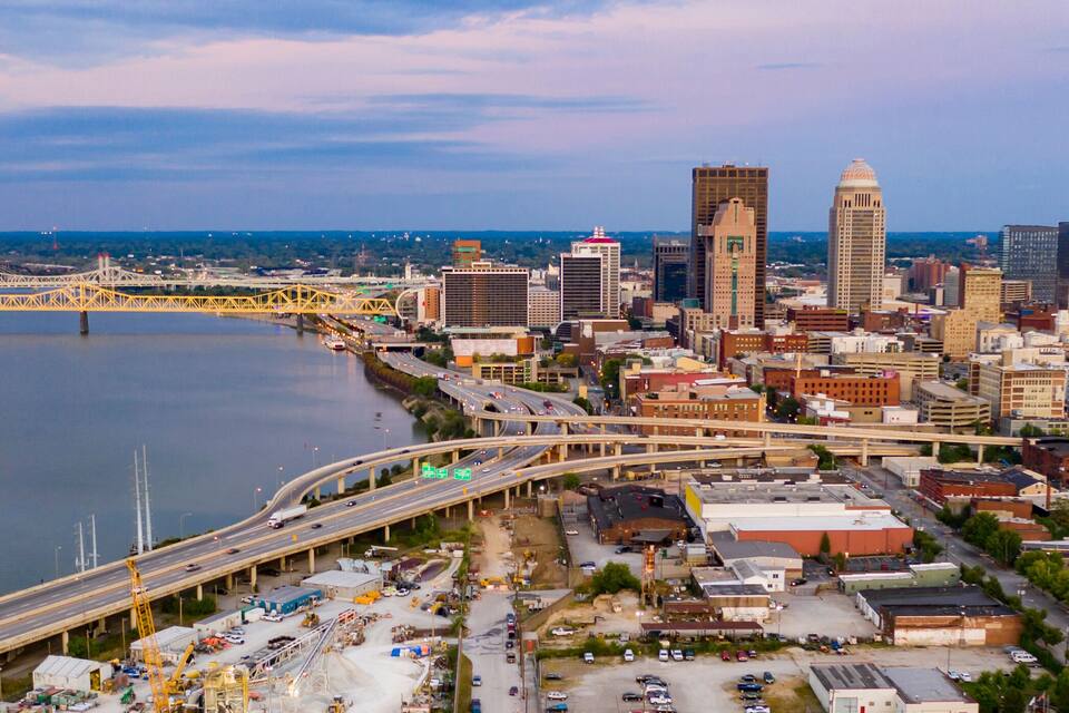 A cityscape with a river, a bridge, and a highway.