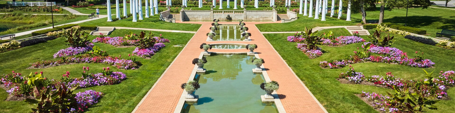 Low aerial pools of water with flowers and white pergola and trellises at Lakeside Park