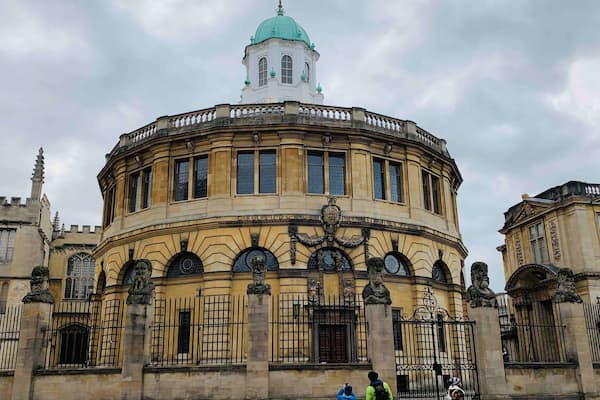 A historic building with a round tower and ornate iron gates.