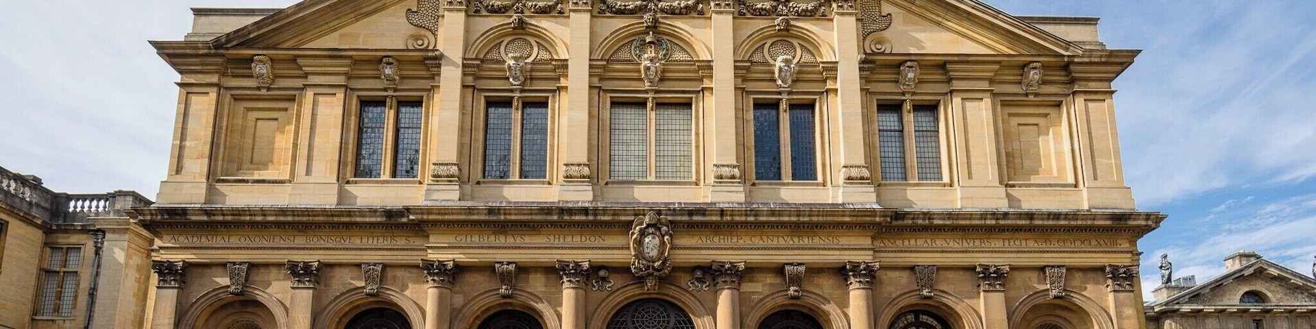 Um imponente edifício em estilo clássico com uma grande porta central, janelas em arco e colunas decorativas.