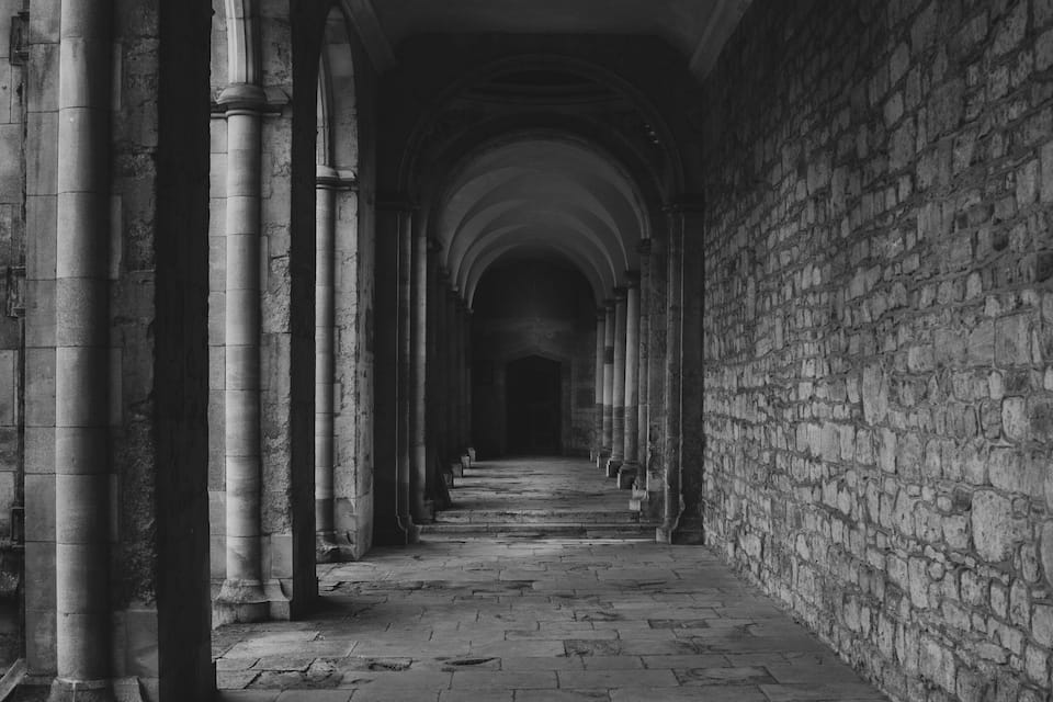 A long corridor with stone walls and columns.
