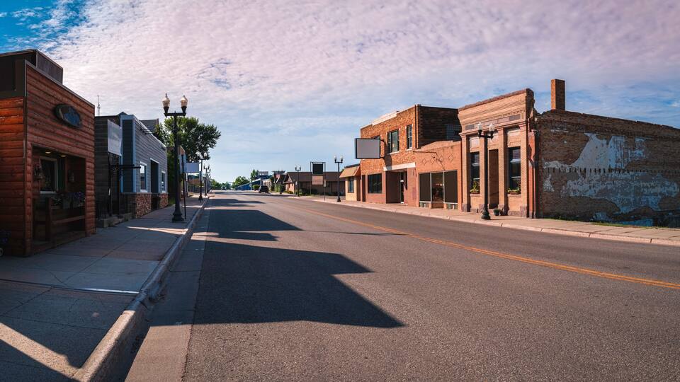 A quiet street lined with historic buildings and a clear blue sky.