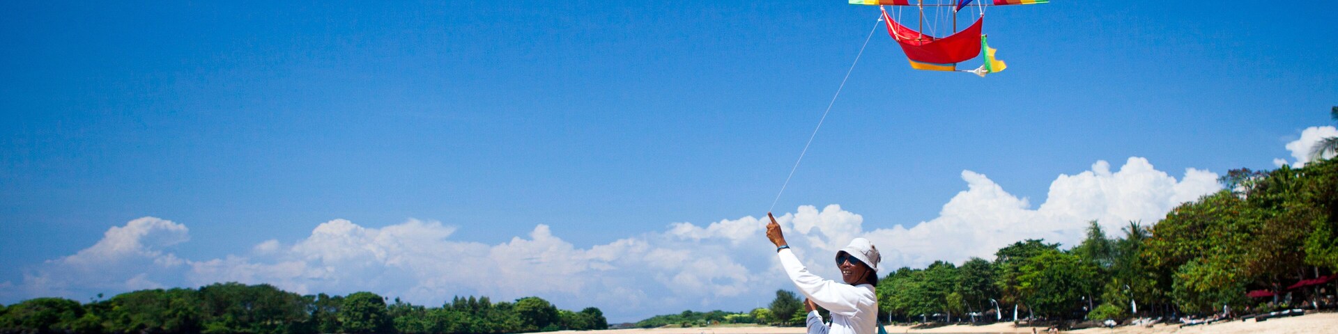 CF849N Indonesia, Asia, Bali Island, Laguna Nusa Dua, Resort, Beach, ship, colourful, kite, flying, vendor, man
