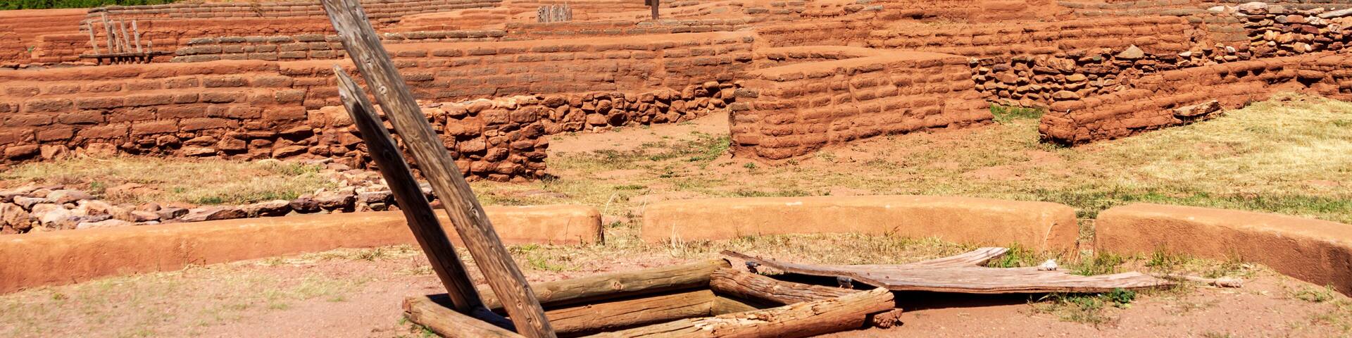 Ancient red-brick ruins with wooden structures in the foreground.