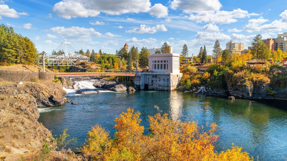 Autumn view of Riverfront Park in downtown, with the pavilion, clock tower rising above the Spokane River, Upper Falls and the Post Street Bridge, in Spokane, Washington State, USA.