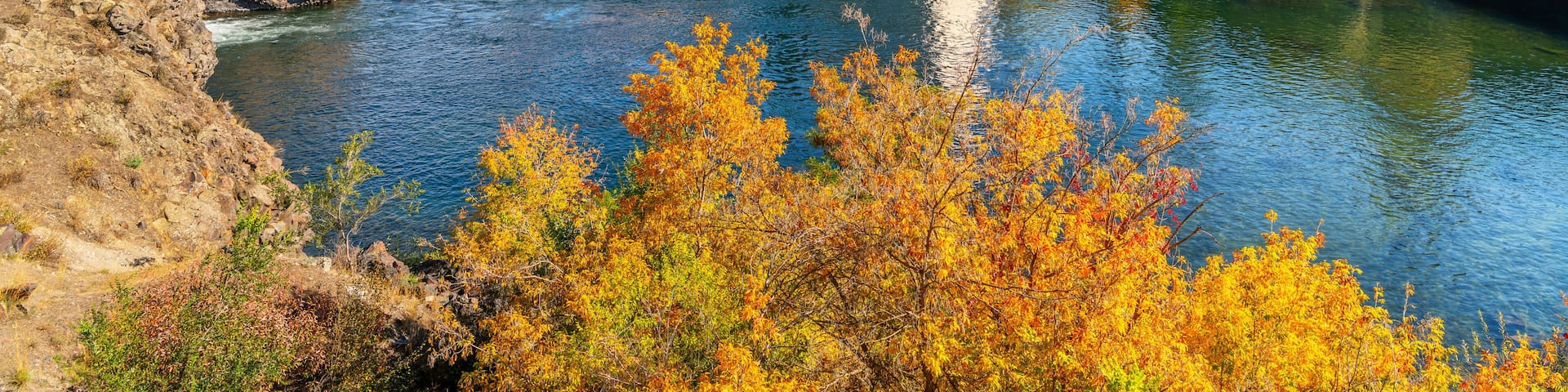 Autumn view of Riverfront Park in downtown, with the pavilion, clock tower rising above the Spokane River, Upper Falls and the Post Street Bridge, in Spokane, Washington State, USA.