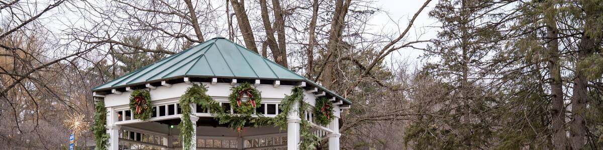 Festive whitewashed gazebo in a park, decorated for Christmas