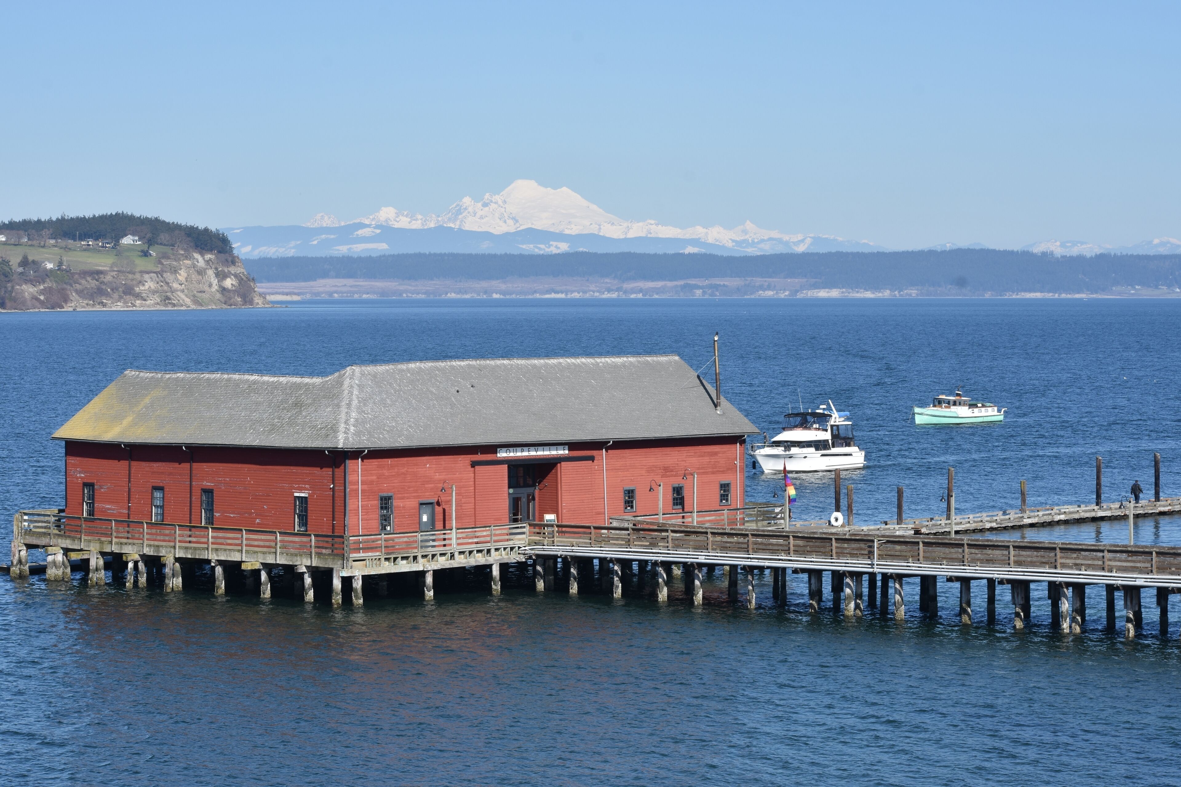 Beautiful March day above Penn Cove, overlooking the wharf with a large boat pulling in to dock.