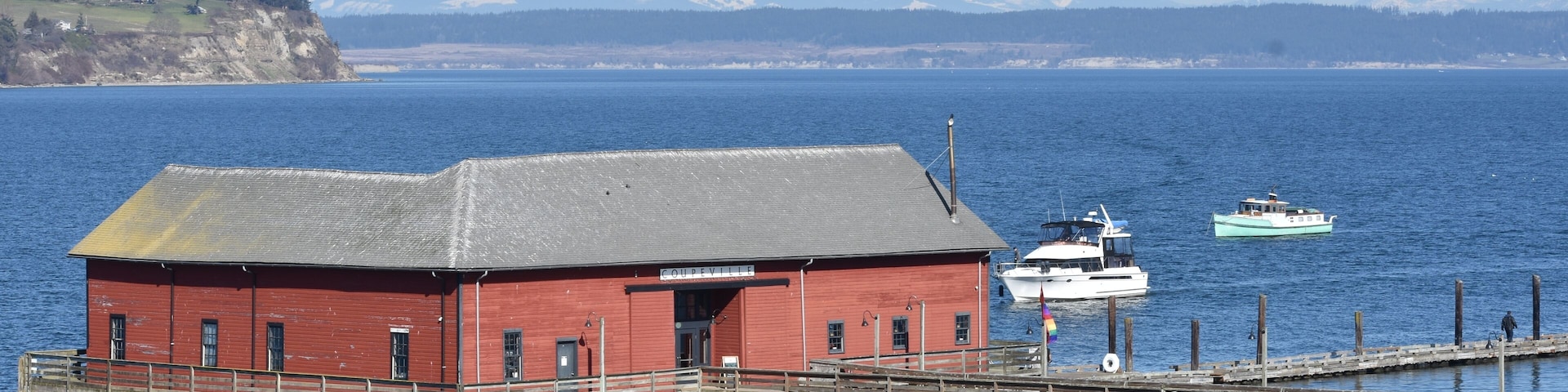 Beautiful March day above Penn Cove, overlooking the wharf with a large boat pulling in to dock.