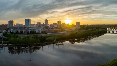 Aerial view of downtown New Brunswick and Rutgers University as the sun sets behind the high rise buildings and reflect on the Raritan river
