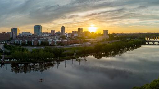 Aerial view of downtown New Brunswick and Rutgers University as the sun sets behind the high rise buildings and reflect on the Raritan river