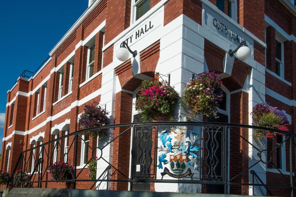 A red brick building with white trim and a sign that reads "CITY HALL".
