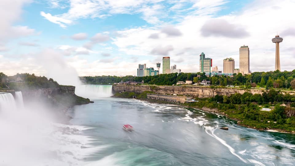 A cityscape with a large waterfall and a tower.