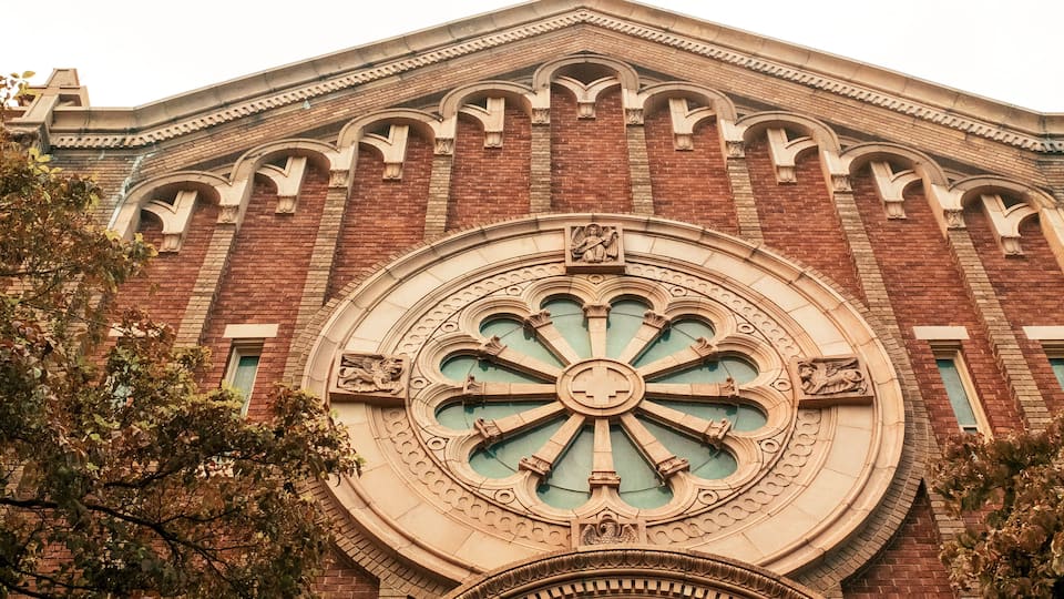 A building with a large circular window and brickwork.