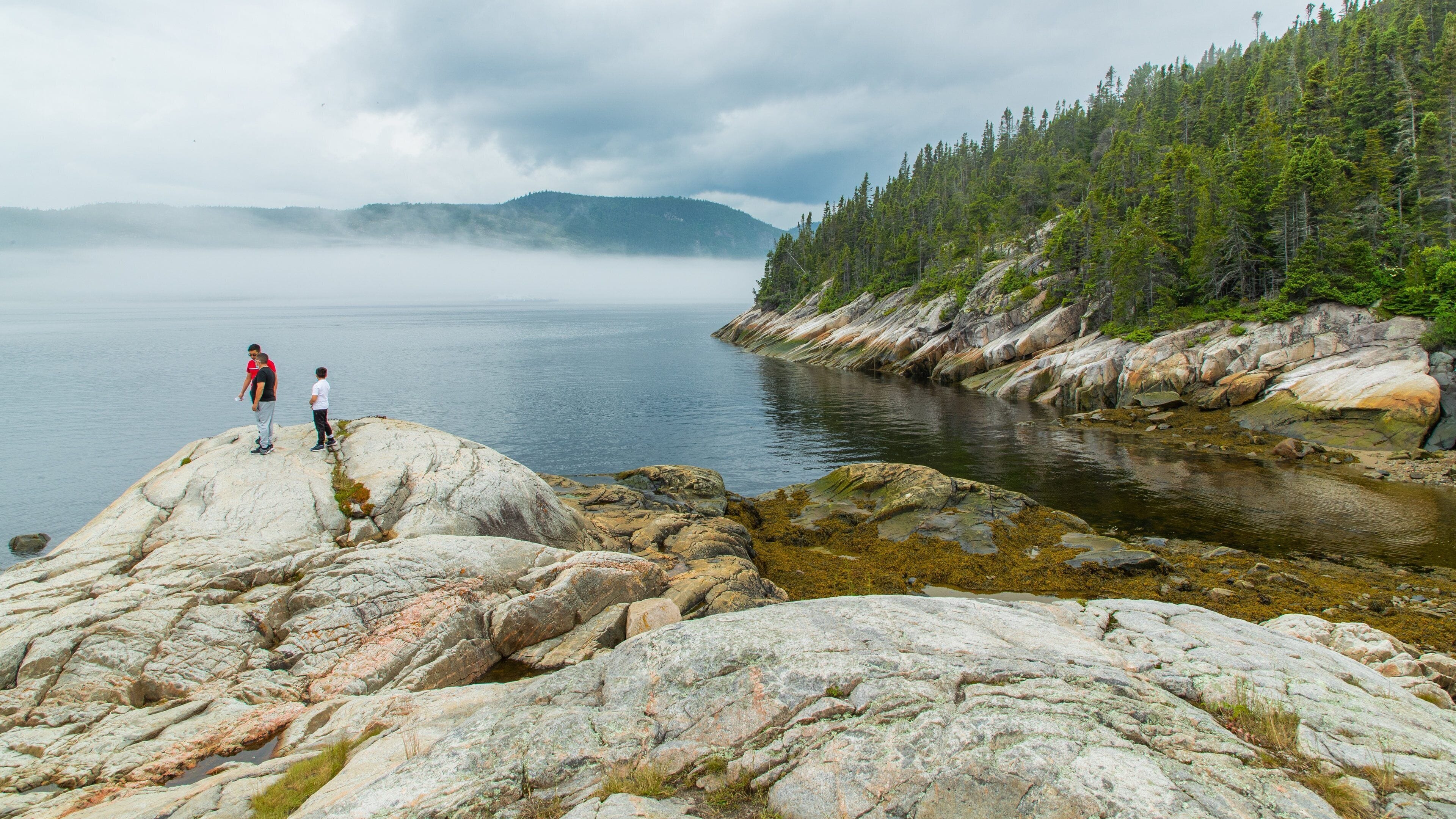 Tadoussac showing a lake or waterhole as well as a small group of people