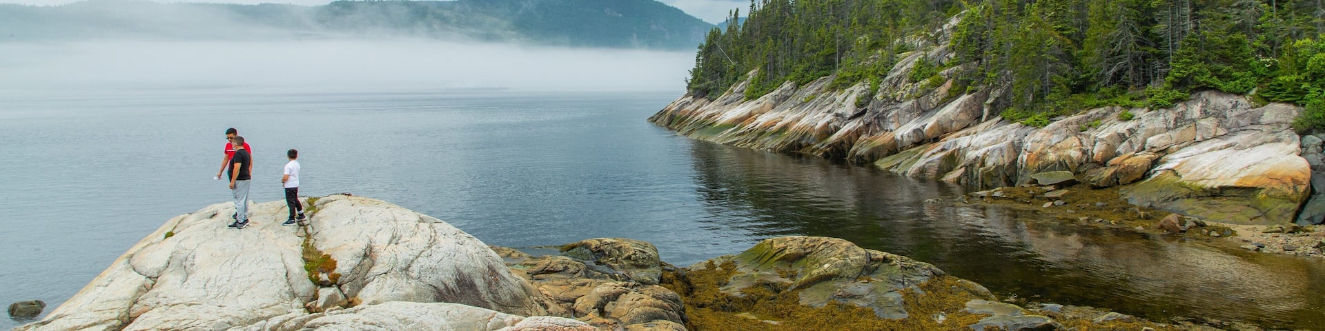 Tadoussac showing a lake or waterhole as well as a small group of people