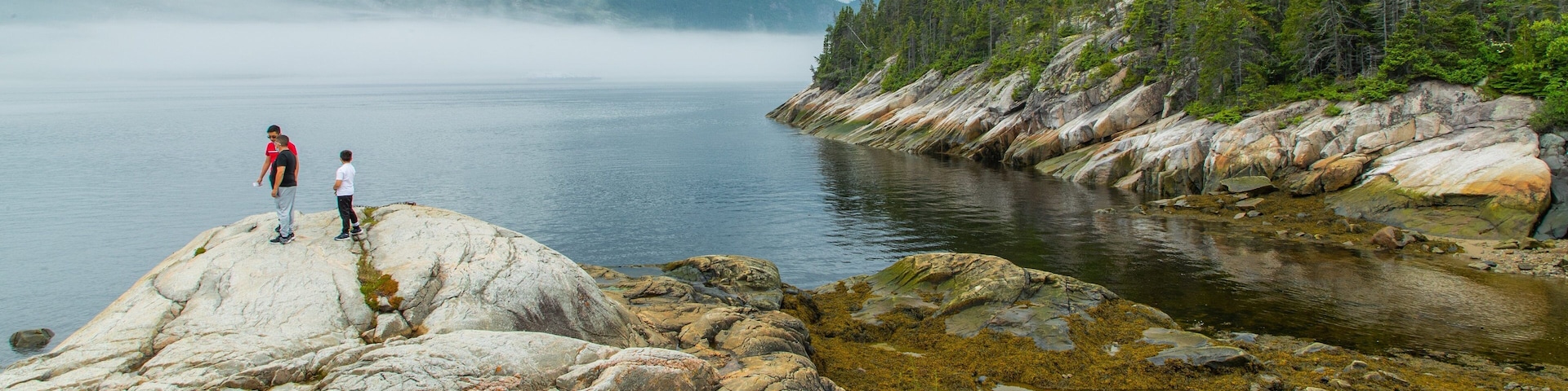 Tadoussac showing a lake or waterhole as well as a small group of people